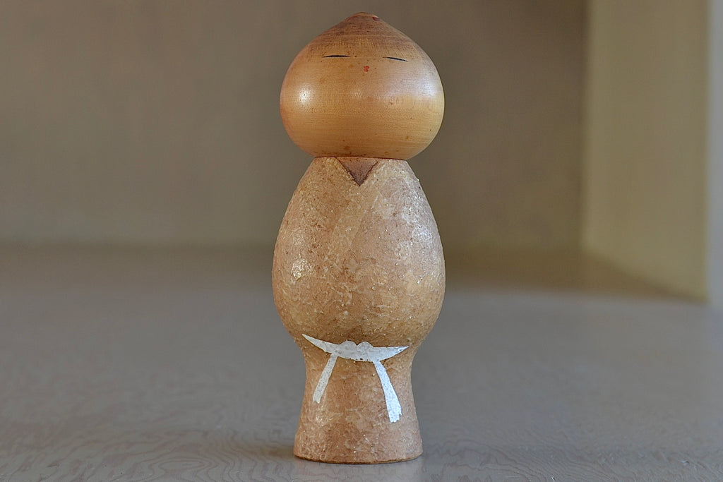 An artisan Kokeshi dolls called Muchin (Innocense) in small. These depict a child with a boyish look. Handmade in Japan by Misao Watanabe (1917-2007), possibly the most popular Sosaku artisans. He won the Prime Minister's Prize in 1963 and 1981. 