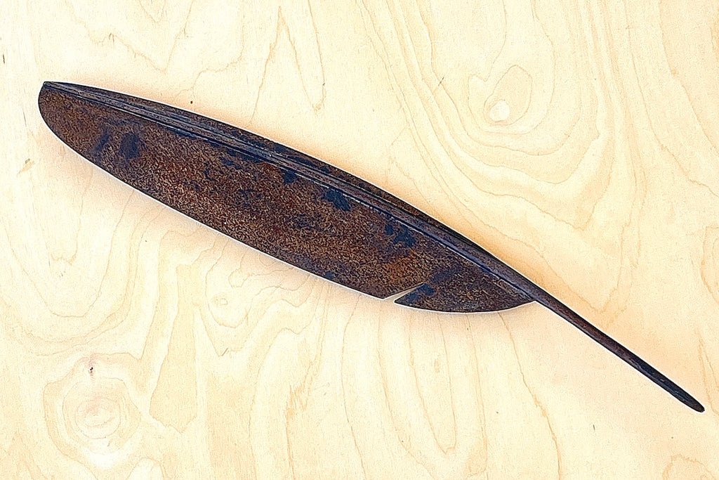 A sculpture of a feather to double as a fountain pen rest 3650 in patina.  Designed by Carl Auböck and handmade in Austria. Founded in 1906, the workshop is still owned and operated by the Auböck family. fountain pen rest.