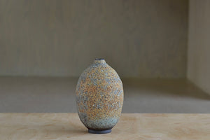 Short hand thrown stoneware vase with volcanic glaze in green and orange by Heather Rosenman. 