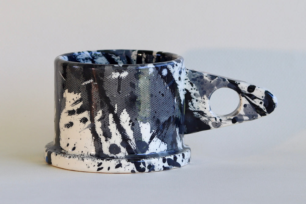 Black and gray with blue and red spots EXP splatter mug available at OK.