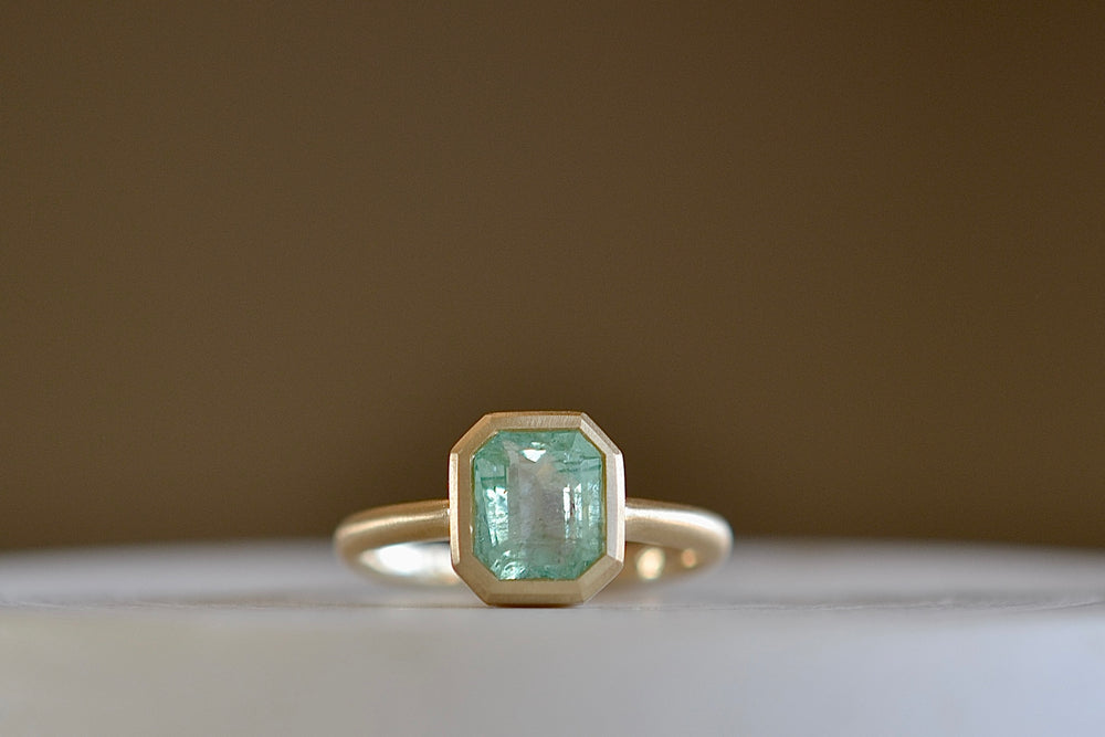 Simple Emerald Rectangular ring by Elizabeth Street made with a pale Columbian emerald.