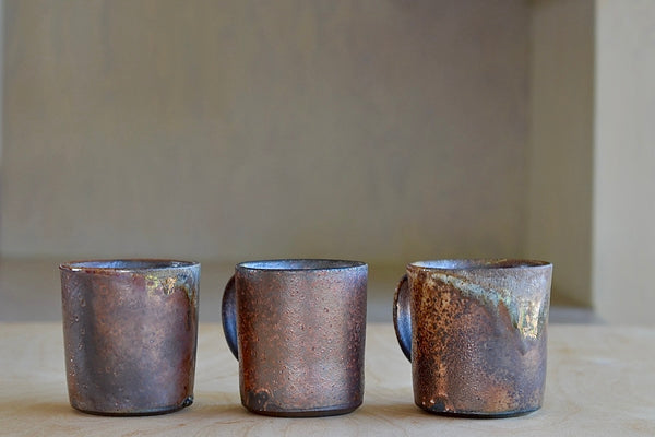 Selection of wood fired ceramic mugs by Lindsey Oesterritter. Wood ash in the kiln results in highly varying surfaces so each one unique,. As beautiful as they are functional. Sizes vary slightly, glazes considerably. These are part of our web selection and numbered 1, 2 and 3.