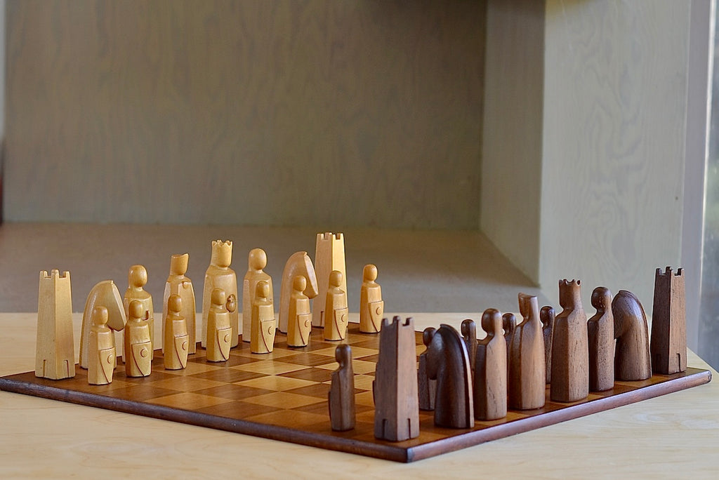 The Vintage Anri Elsinore  Chess Set in Original Wooden Box is a A Vintage Anri Elsinore Chess set in box with original board. The Anri Elsinore chess set was designed by animator, Arthur Elliott, and produced between 1961-1984. Each piece is hand carved, weighted and felted. The king measures 4" . The chess pieces come in its original Mahogany case with trays. The board has some scratches and stains. It is in very good vintage condition. Produced in Val Gardena in the Tyrolean 