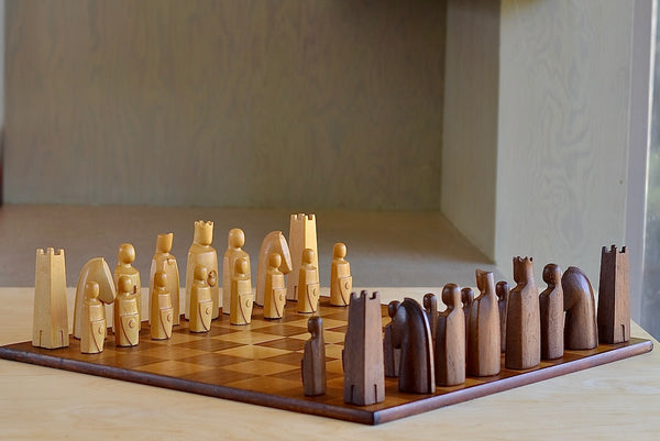 The Vintage Anri Elsinore  Chess Set in Original Wooden Box is a A Vintage Anri Elsinore Chess set in box with original board. The Anri Elsinore chess set was designed by animator, Arthur Elliott, and produced between 1961-1984. Each piece is hand carved, weighted and felted. The king measures 4" . The chess pieces come in its original Mahogany case with trays. The board has some scratches and stains. It is in very good vintage condition. Produced in Val Gardena in the Tyrolean 