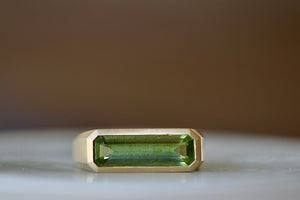 Peridot Bar Signet ring by Elizabeth Street Jewelry is a bezel set elongated peridot stone on a brushed gold 14k band.