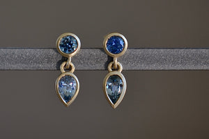 Montana Sapphire Duo Drop Earrings by Elizabeth Street are various shades of blue and round on top and pear cut on the bottom with post closure.