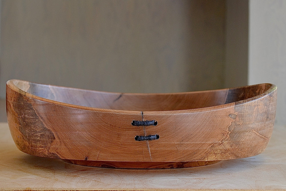 Circle Factory bowl in Maple by Geoarge Peterson is a blonde wood apple bowl with repairs deatail.