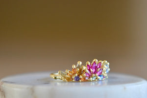 Side view of Rainbow Daisy Garland Petal Ring by Polly Wales. 