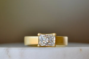 Wide Band Solitaire by Elizabeth Street Jewelry is a radiant cut and prong set lab grown diamond (1.01ct) H/VS2 on an 18k yellow gold band with satin finish. Handmade in Los Angeles.