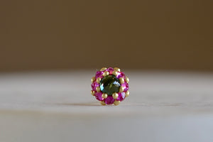 Larkspur stud earring by Polly Wales is a single earring is a smaller floral cluster made out of a half sphere in gold with a cabochon and encrusted inverted brilliant sapphires. We have one in green and pink