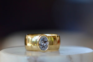 Wide oval Solitaire Signet ring by Elizabeth Street Jewelry is a bezel set and oval cut salt and pepper diamond signet ring on a wide and slightly domed 14k yellow gold band that can also work as an engagement ring. Handmade in Los Angeles.