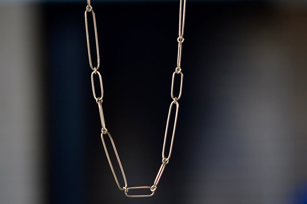 Long 14k gold paperclip chain with two short, one long flat clips in 17 inches by Kaylin Hertel.