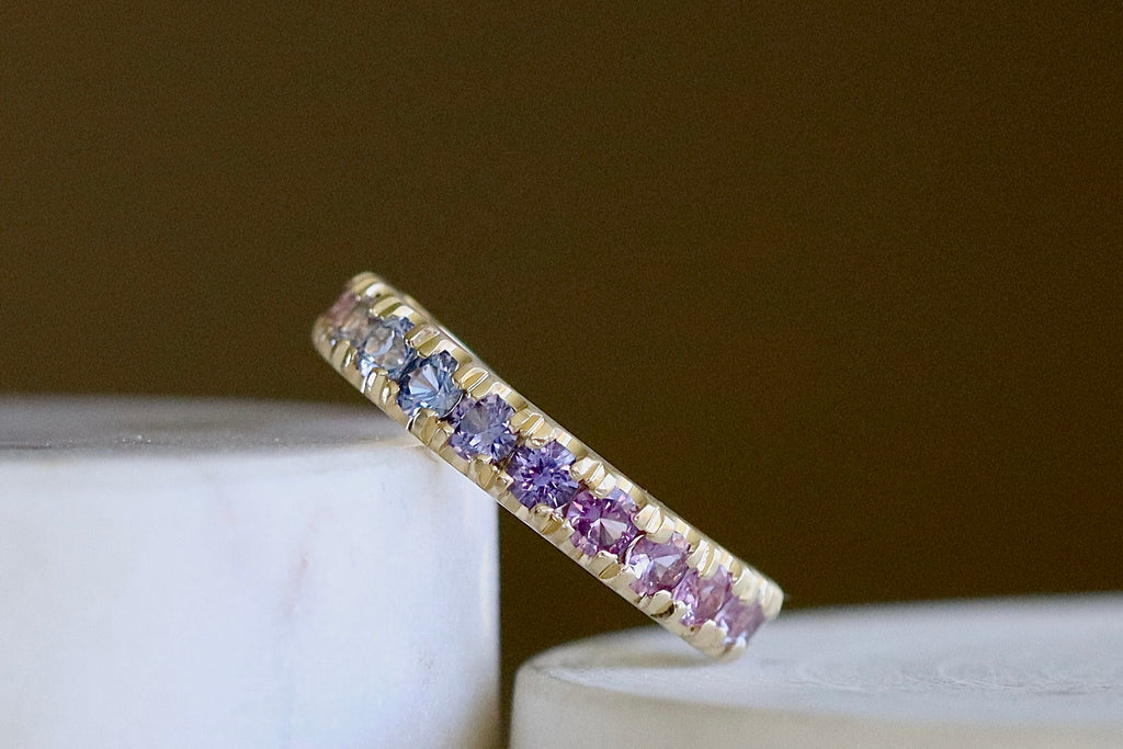 Purple Ombre Sapphire Euro Band by Elizabeth Street Jewelry is a gradient of mid purple to pink rose cut sapphires set into a&nbsp; euro eternity band in 14k gold. This band has a nearly flat back/underside for ultimate comfort and is perfect for stacking. Handmade in Los Angeles.
