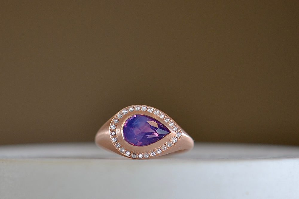 Sapphire Pear cut ring with Halo by Elizabeth Street Jewelry is a pear cut silky sapphire with a white diamond halo in rose gold.
