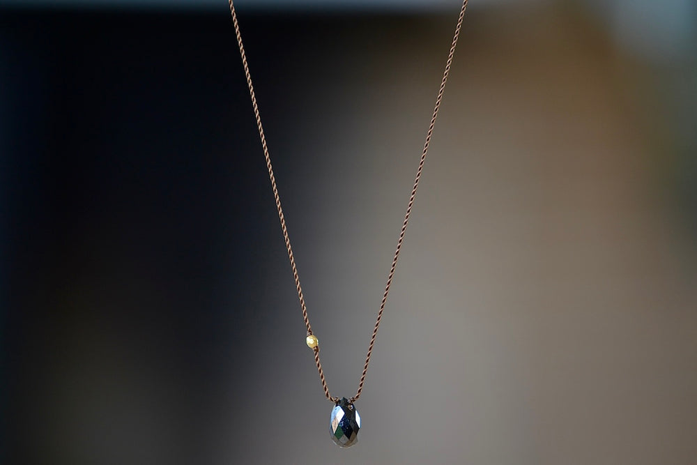 Black Diamond and 18K Bead Pendant Necklace A raw and faceted black diamond is accented with an 18k gold bead on poly nylon string to form this one of a kind organic necklace. Designed by Margaret Solow. Handcrafted in Los Angeles.