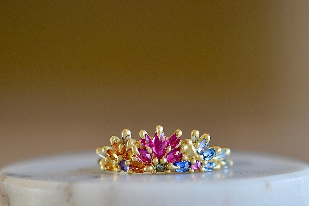 Rainbow Daisy Garland Ring y Polly Wales is a ring of Encrusted rainbow sapphires on a petal crown ring in 18k recycled yellow gold. Cast in Place. Cast not set. Handcrafted in Los Angeles. 