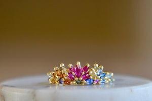 Rainbow Daisy Garland Ring y Polly Wales is a ring of Encrusted rainbow sapphires on a petal crown ring in 18k recycled yellow gold. Cast in Place. Cast not set. Handcrafted in Los Angeles. 