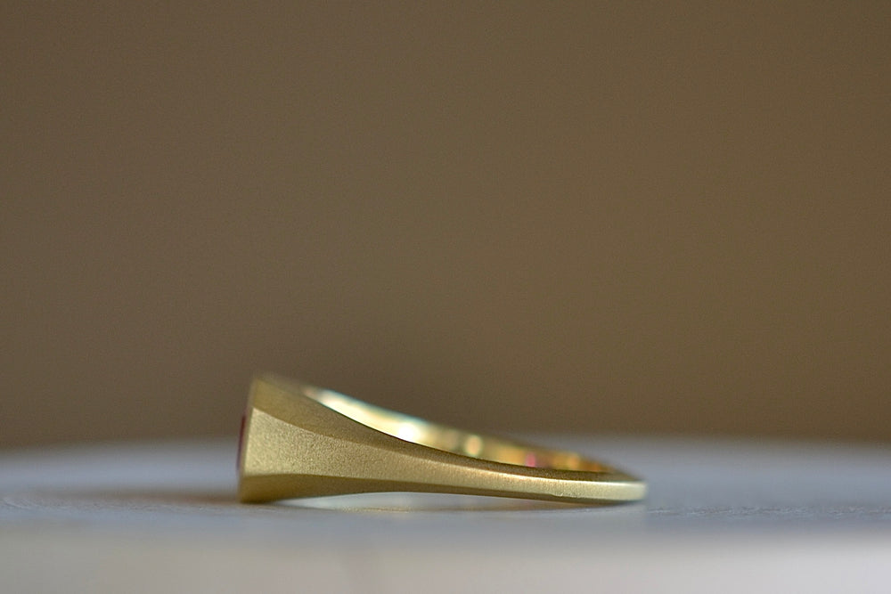 Side view of Ruby Signet by Elizabeth Street in size 7 with tapered matte 18k gold band.