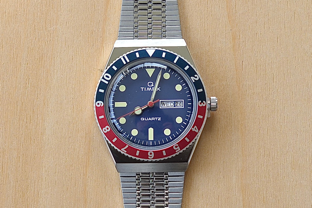 Close up of Timex Q Diver Reissue Watch Blue Face, Blue and red bezel 38mm TW2U613002V silver bracelet 