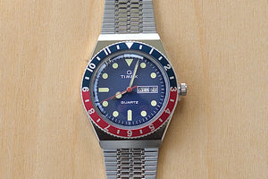 Close up of Timex Q Diver Reissue Watch Blue Face, Blue and red bezel 38mm TW2U613002V silver bracelet 