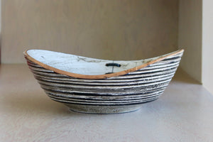 Another angle of Circle Factory Black and white bowl with mending.
