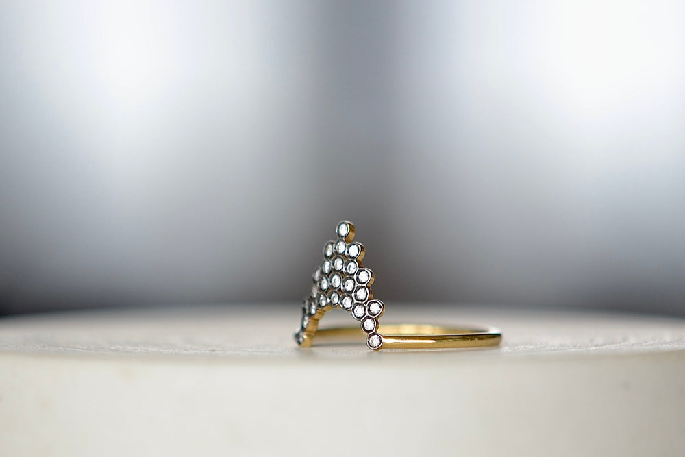 Side view of Pétale  Ring in size 6.5 by Yannis Sergakis is a triangular formation of twenty-five bezel set and rhodium plated round cut diamonds on a gold band in 18k gold. Minimalist and designed to be worn every day.