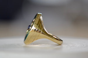 Side view of Retrouvai Turquoise Compass Signet ring with Diamonds and tanzanite accent stone in 14k yellow gold and inlay.