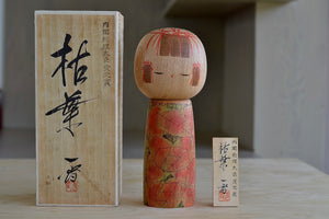 Kokeshi doll with box and placard.