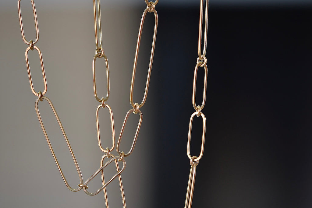 Detail of long and short 14k gold paperclip chains (necklaces) with two short, one long flat clips in 15 or 17 inches by Kaylin Hertel.