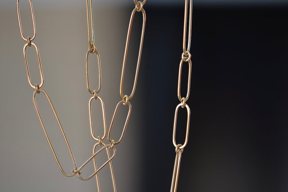 Detail of long and short 14k gold paperclip chains (necklaces) with two short, one long flat clips in 15 or 17 inches by Kaylin Hertel.