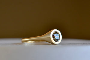 Side view of Champagne Solitaire signet by Elizabeth Street in a matte gold band.