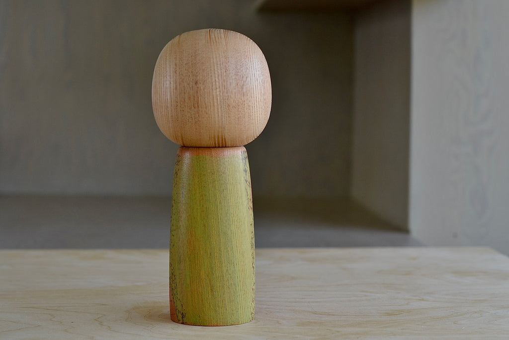 The back of the kokeshi doll is a yellow green.