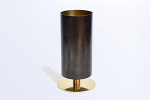 Studio shot of the thin rimmed patina brass tube vase with polished b