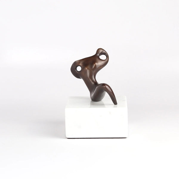 Anne Ricketts Repose Sculpture of modern woman in brass on white background. Muse.