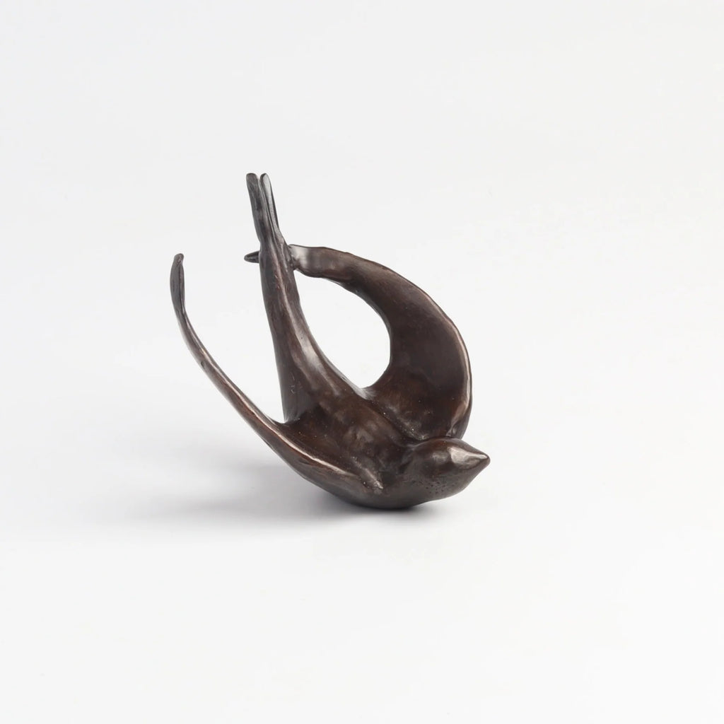 Bronze Object "Coming Home" (flying swallow) on white background by Anne Ricketts.