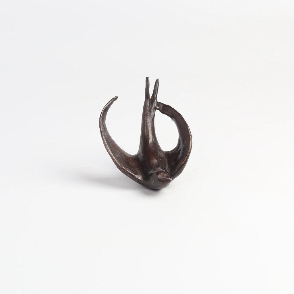 Bronze Object "Coming Home" (flying swallow) on white background by Anne Ricketts.