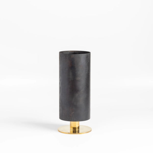 The Aubock Vase on Pedestal in Medium 7247-4 is a thin rimmed patina brass tube vase with polished base in medium designed by Carl Auböck.
