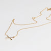 Mini X necklace on white background by Carla Caruso.