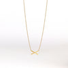 Mini X necklace on white background by Carla Caruso.