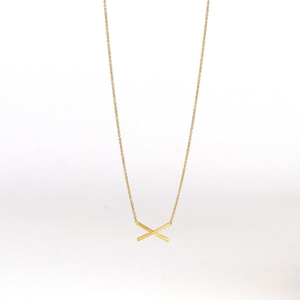 Mini X necklace on white background by Carla Caruso.