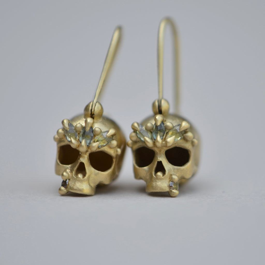 Close up of Green Enchanted Skull Safety Pin Earrings by Polly Wales.