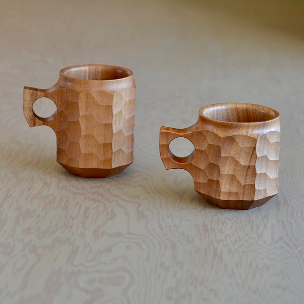 Lifestyle shot of large and medium  wood Jincups from Akihiro Woodworks , a hand carved mug in Tabunoki. 