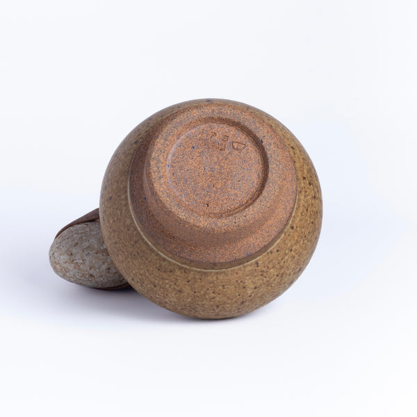 Showing stamp on beige bottle shaped vase by Irving Place Studio (IPS).