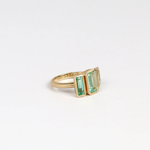 Emerald Trio ring by Elizabeth Street Jewelry comprises of three (3) Columbian emeralds set in 14k yellow gold on a satin brushed round band.