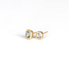 Bezel Set Asymmetrical Studs by Elizabeth Street Jewelry on white background. These are a pair of asymmetrical square/rectangle, soft purpley blue and bezel set sapphire stud earrings with post closure in 14k yellow gold. Handmade in Los Angeles.