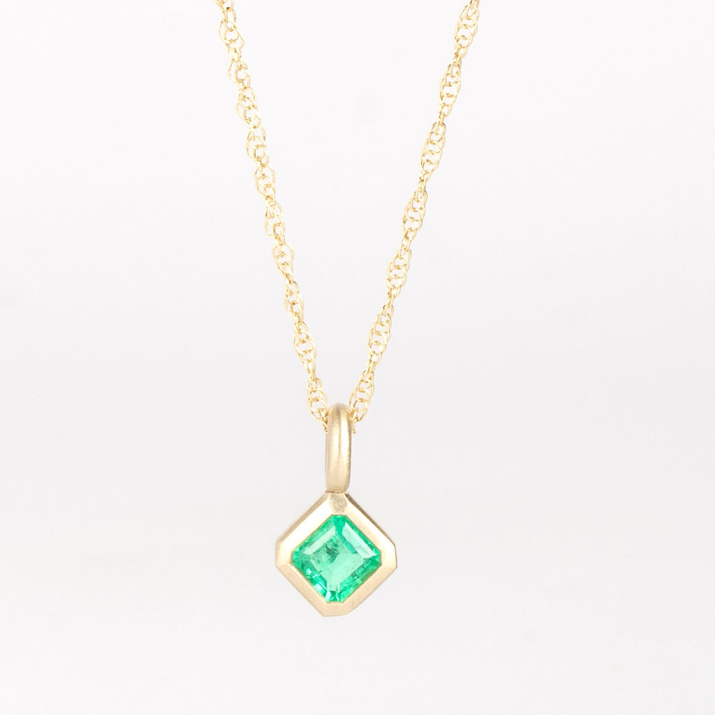 Off-Set Emerald Pendant Necklace by Elizabeth Street Jewelry is a bezel set and off-set square Colombian emerald .42ct on a 14k 18 inch long yellow gold chain. Perfect for layering or to wear as a solo piece. Handmade in Los Angeles.