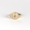 Front of Oval Signet by Elizabeth Street Jewelry. A bezel set oval lab grown diamond in a multi surface circle signet ring on a tapered 14k yellow gold band. Handmade in Los Angeles.