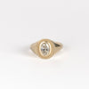 Front of Oval Signet by Elizabeth Street Jewelry. A bezel set oval lab grown diamond in a multi surface circle signet ring on a tapered 14k yellow gold band. Handmade in Los Angeles.