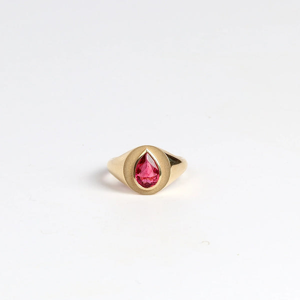 Circle Signet with Pear Tourmaline by Elizabeth Street Jewelry is a multi finish classic circle signet ring with a bezel set rubellite pear tourmaline on a tapered 14k yellow gold band. Handmade in Los Angeles. Size 7.