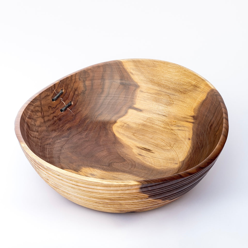 Birds eye view of Circle Factory turned wood bowl in walnut with ridged grooves and stitch detailing by George Peterson. 